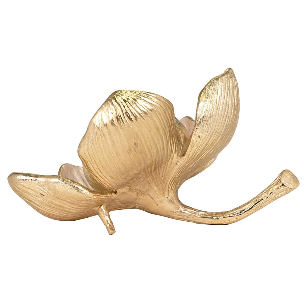 A gold flower sculpture with detailed, textured petals resting on its curved stem against a white background.