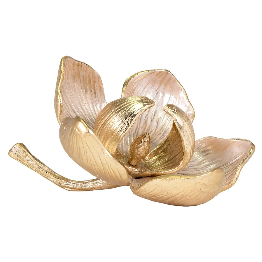 Gold and pale pink flower sculpture resembling an open magnolia with a curved stem on a white background.