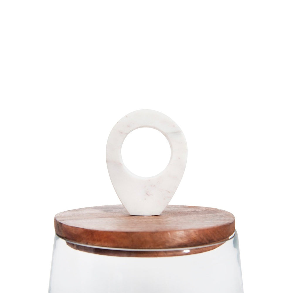 A close-up of a wooden jar lid topped with a white marble ring handle, against a solid white background.