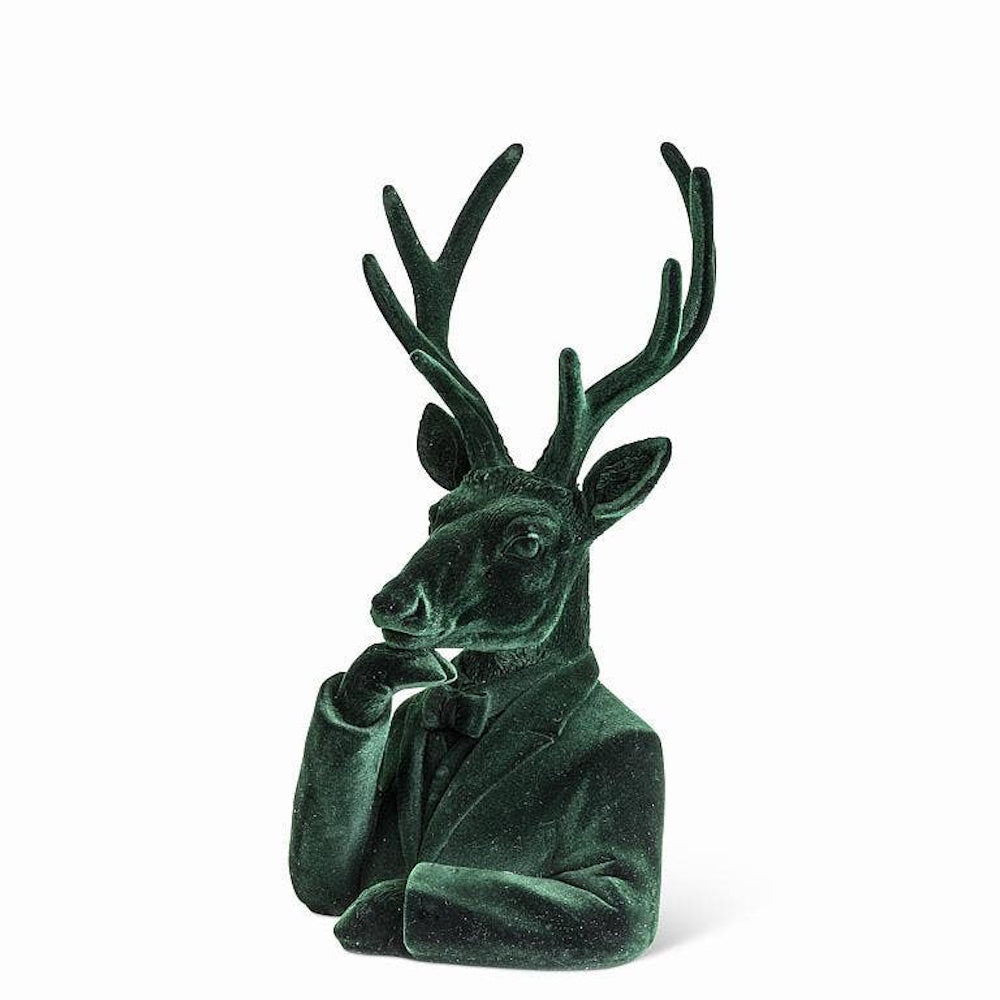 Green velvet stag bust in a suit with hand resting thoughtfully under its chin.