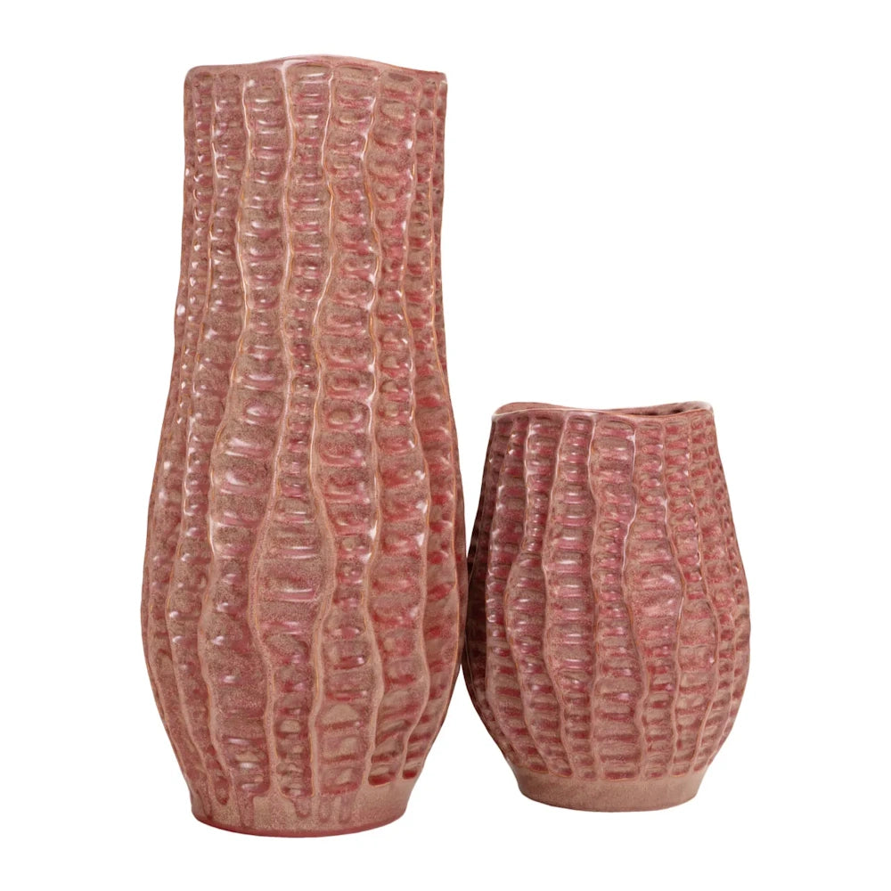 Two textured, dusty pink ceramic vases of different heights with vertical ridges, side-by-side on a white background.