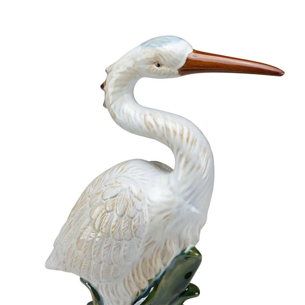 Ceramic white heron figurine with a long brown beak and an S-curved neck against a solid white background.