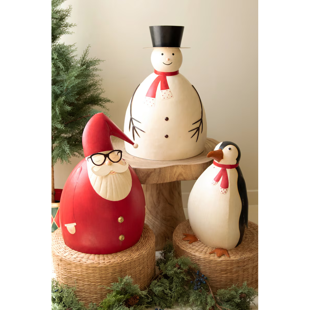 Trio of painted metal Christmas sculptures including Santa, a snowman, and a penguin.