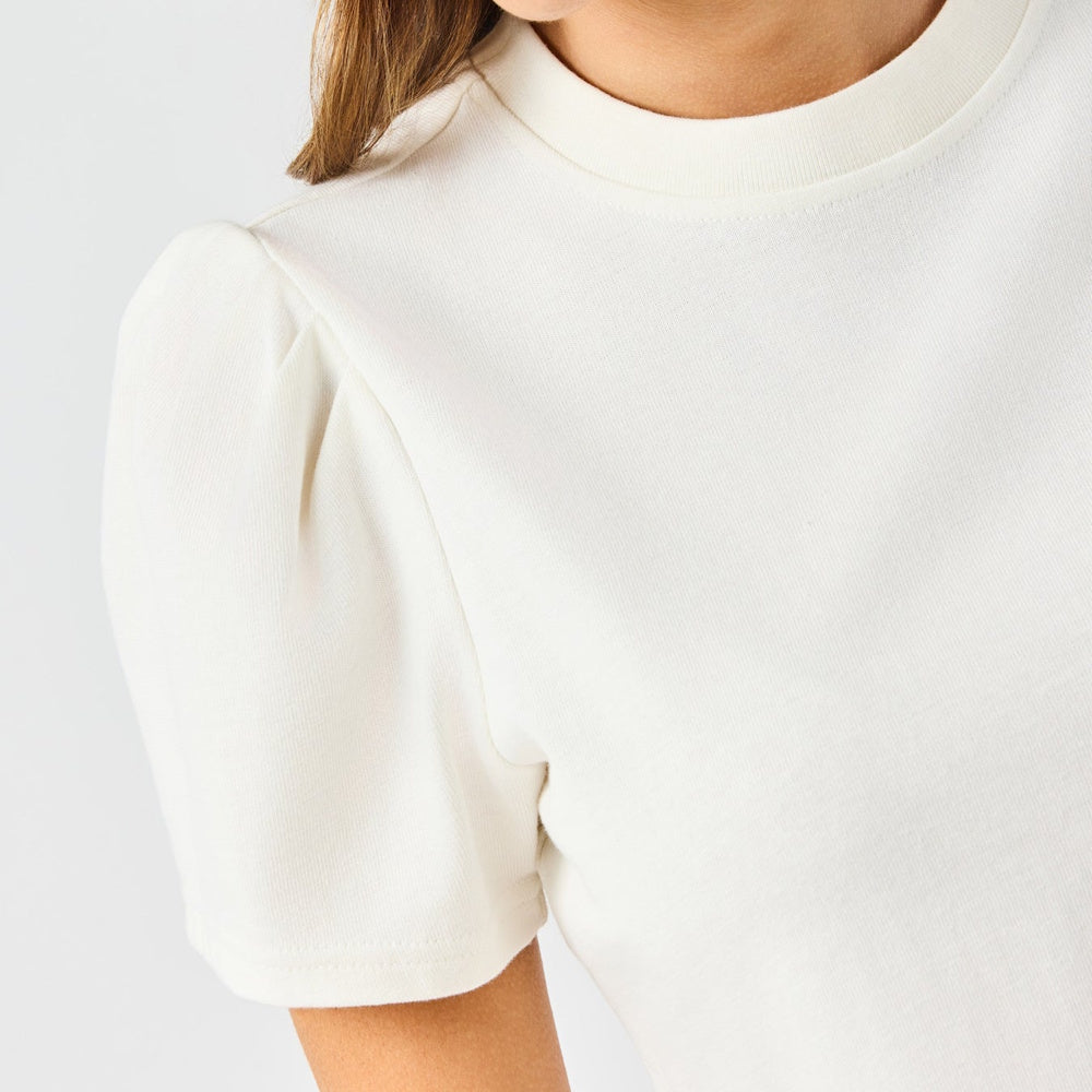 Close-up view of an off-white crewneck t-shirt with pleated puff sleeves.