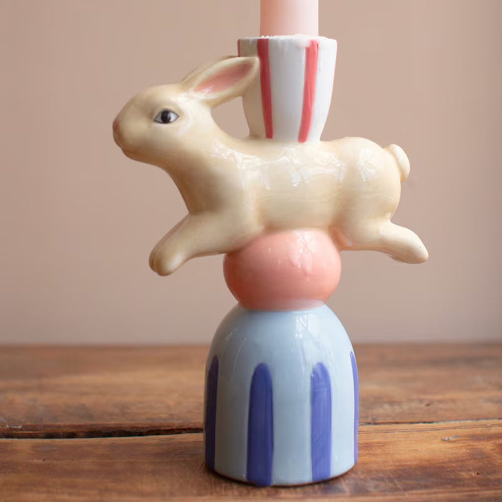 Ceramic bunny taper candle holder with a colorful striped base and a whimsical leaping rabbit design.