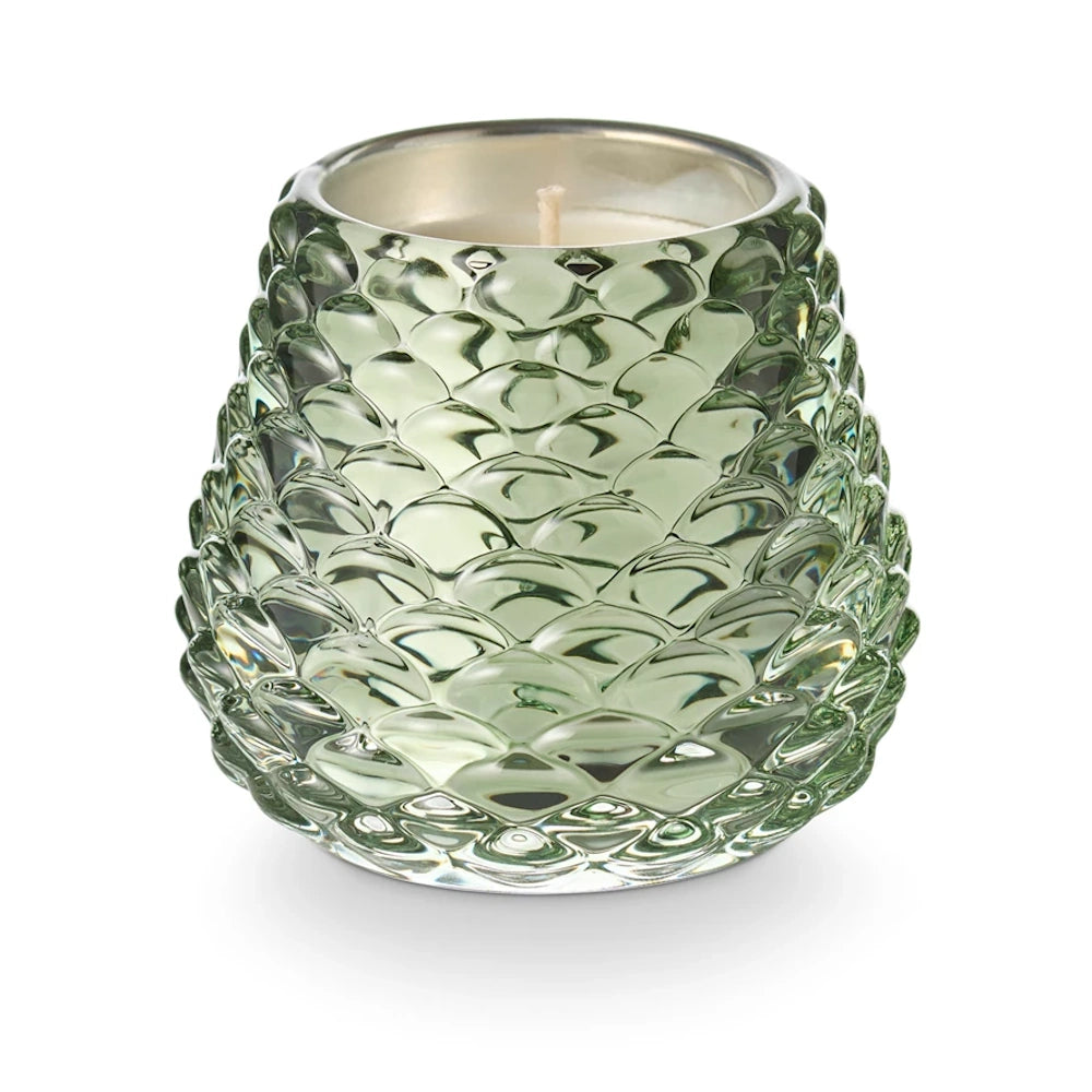Green textured glass pinecone votive candle holder with a white wax candle.