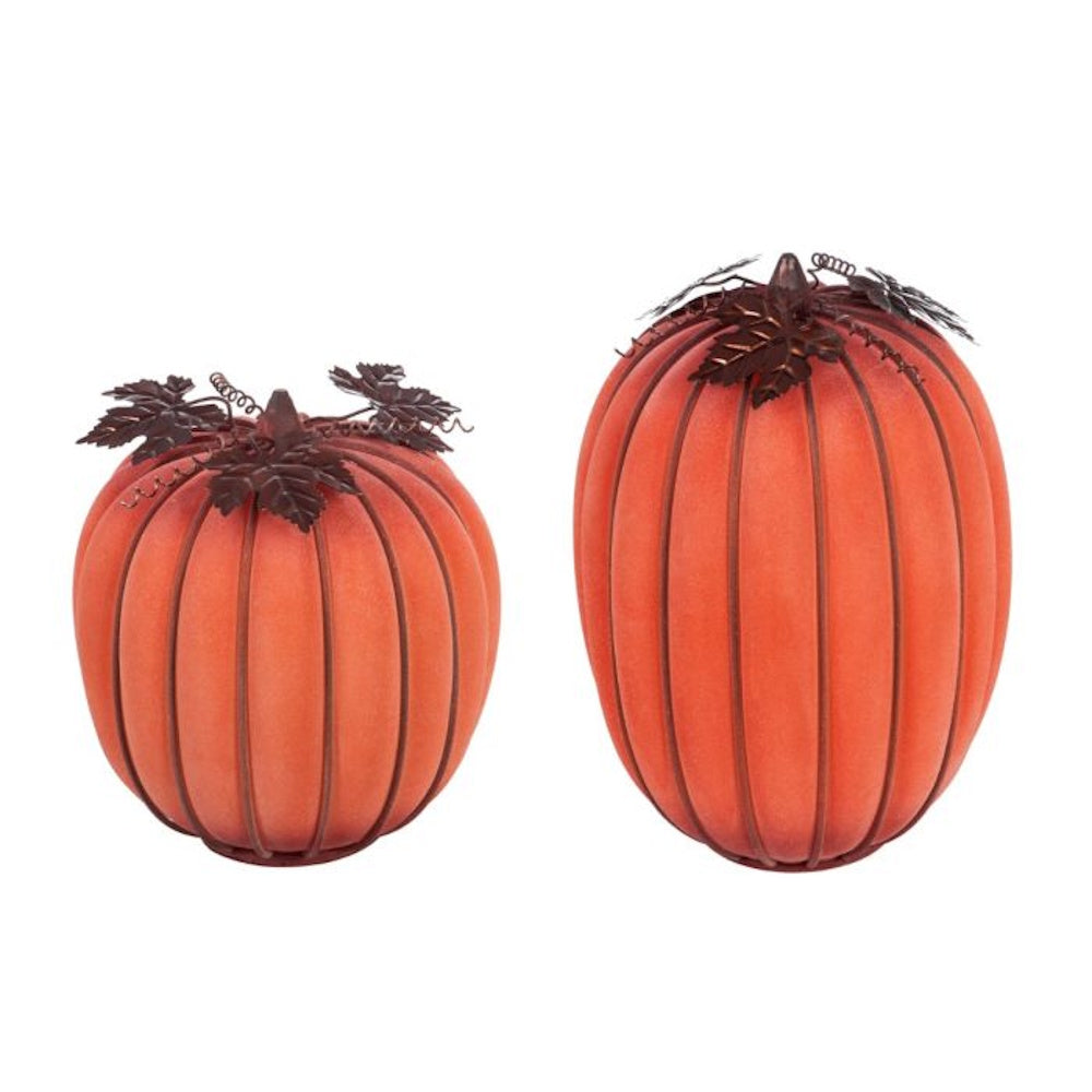 Two orange, ribbed glass decorative pumpkins with metal frames and leaves on a plain background.