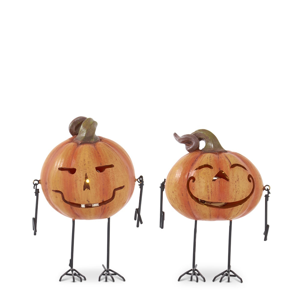 Two jack-o'-lantern pumpkin decorations with skinny metal arms and bird-like legs on a white background.