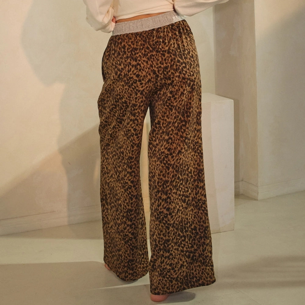 Back view of leopard-print wide-leg lounge pants showing the gray ribbed waistband.