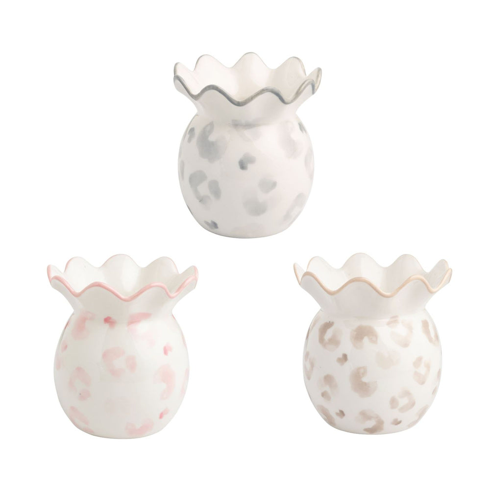 Set of three small white ceramic leopard print bud vases with ruffled rims in grey, pink, and tan leopard patterns.