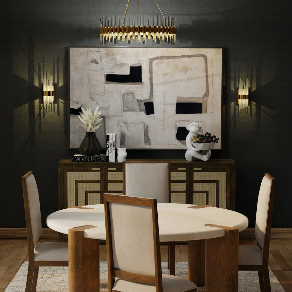 Modern dining room with a round marble table, beige chairs, gold chandelier, and abstract wall art over a wood sideboard.