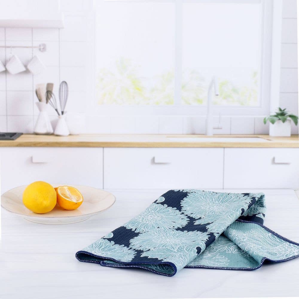 Blue and white chrysanthemum floral eco-friendly tea towel on a kitchen counter with lemons in a bowl.
