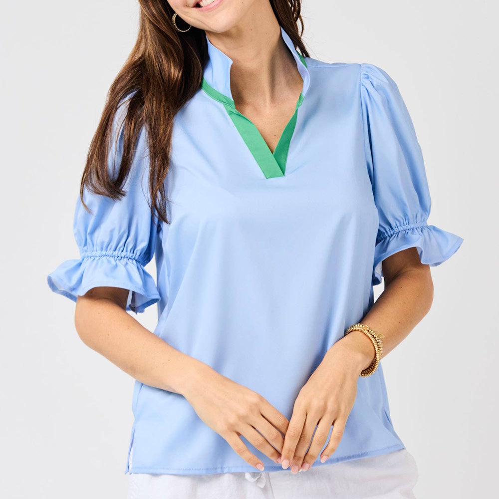 Light blue blouse with ruffled puff sleeves and a green-lined stand-up v-neck collar.