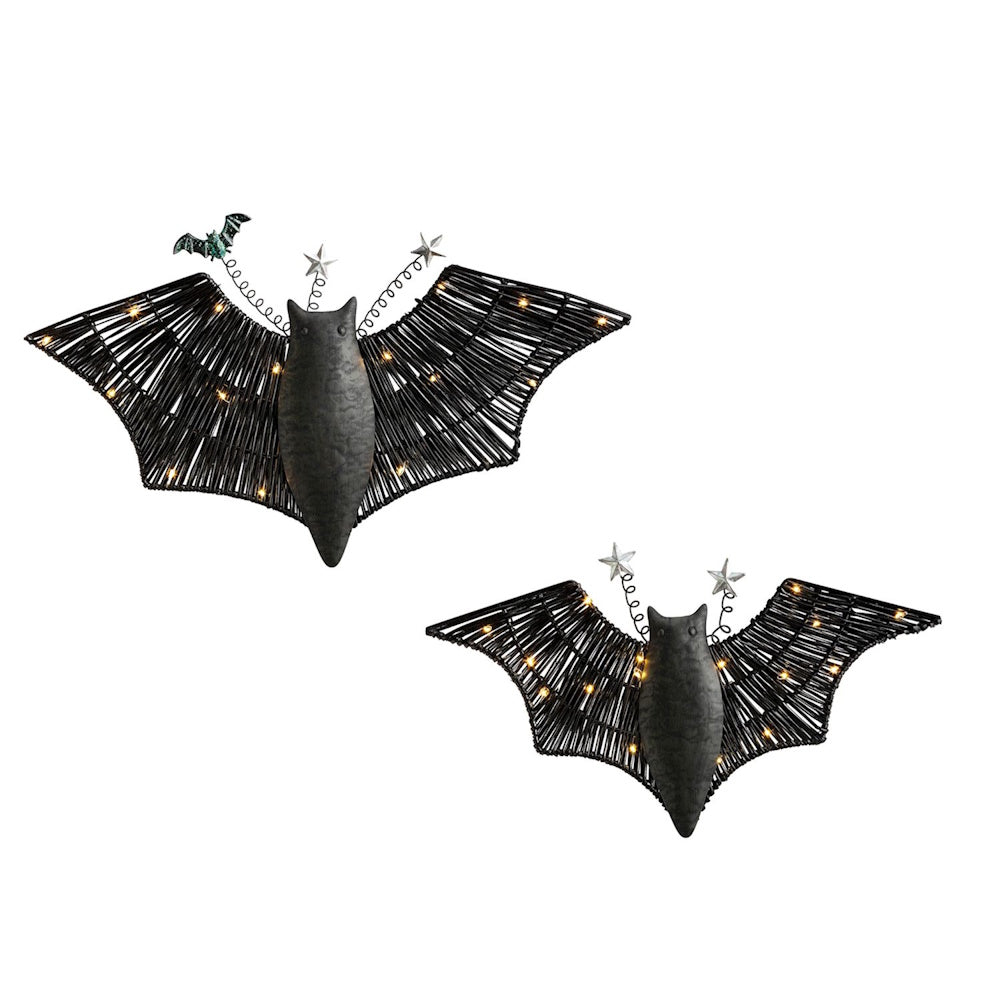 Two light-up black bat wall decorations with woven wings, fairy lights, and star toppers.