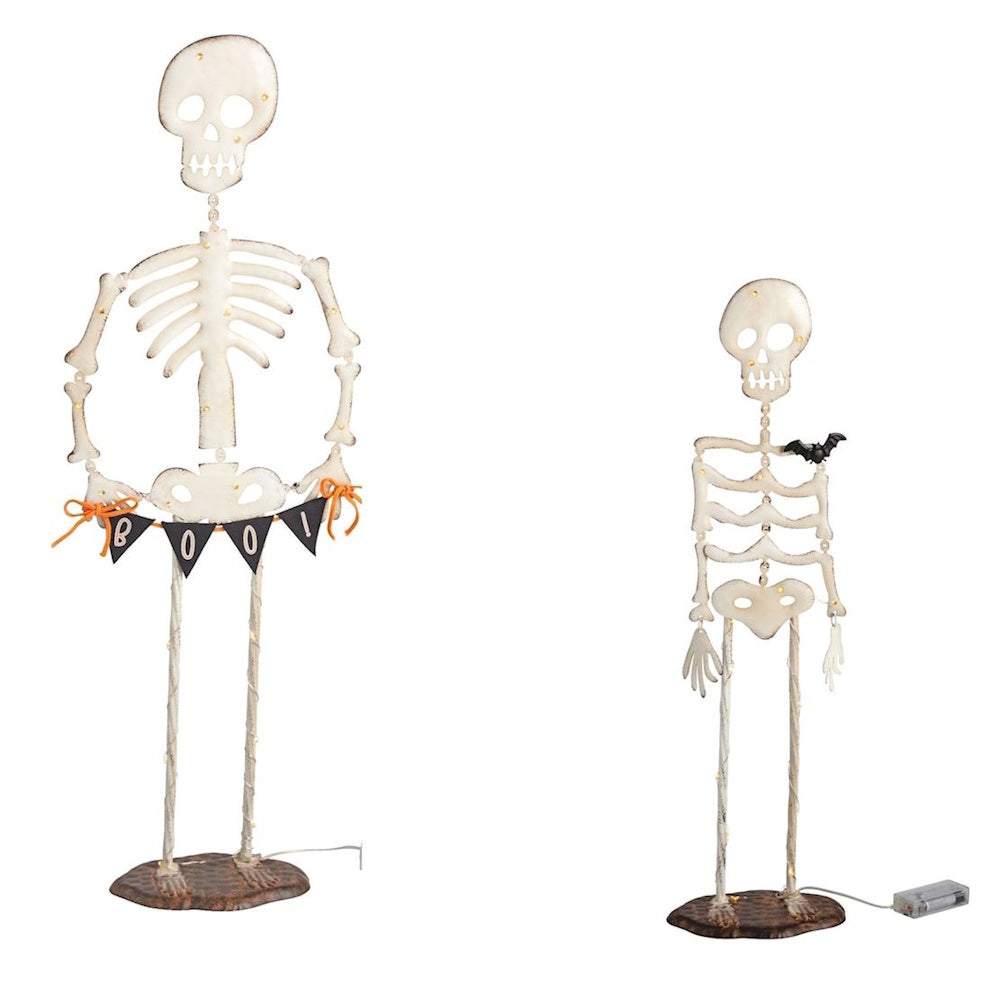 Two light-up skeleton Halloween decorations on a white background, one holding a black "BOO!" banner.