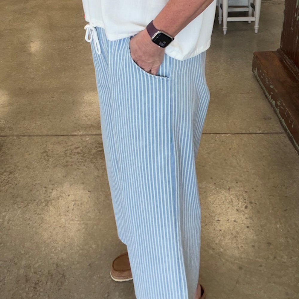 Light denim stone wash stripe wide-leg pants with side pockets and a white drawstring waistband.