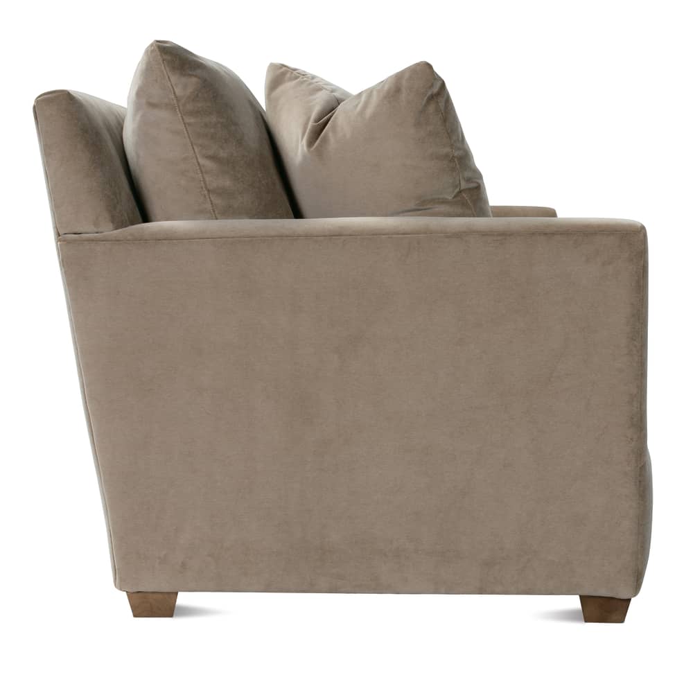 Side profile of a modern taupe velvet sofa with plush back cushions.