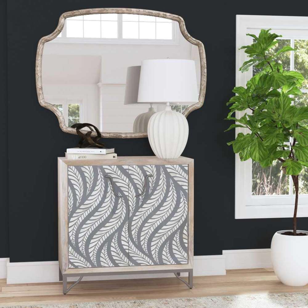 Modern gray leaf pattern cabinet with a scalloped wall mirror and white lamp in a stylish living room.