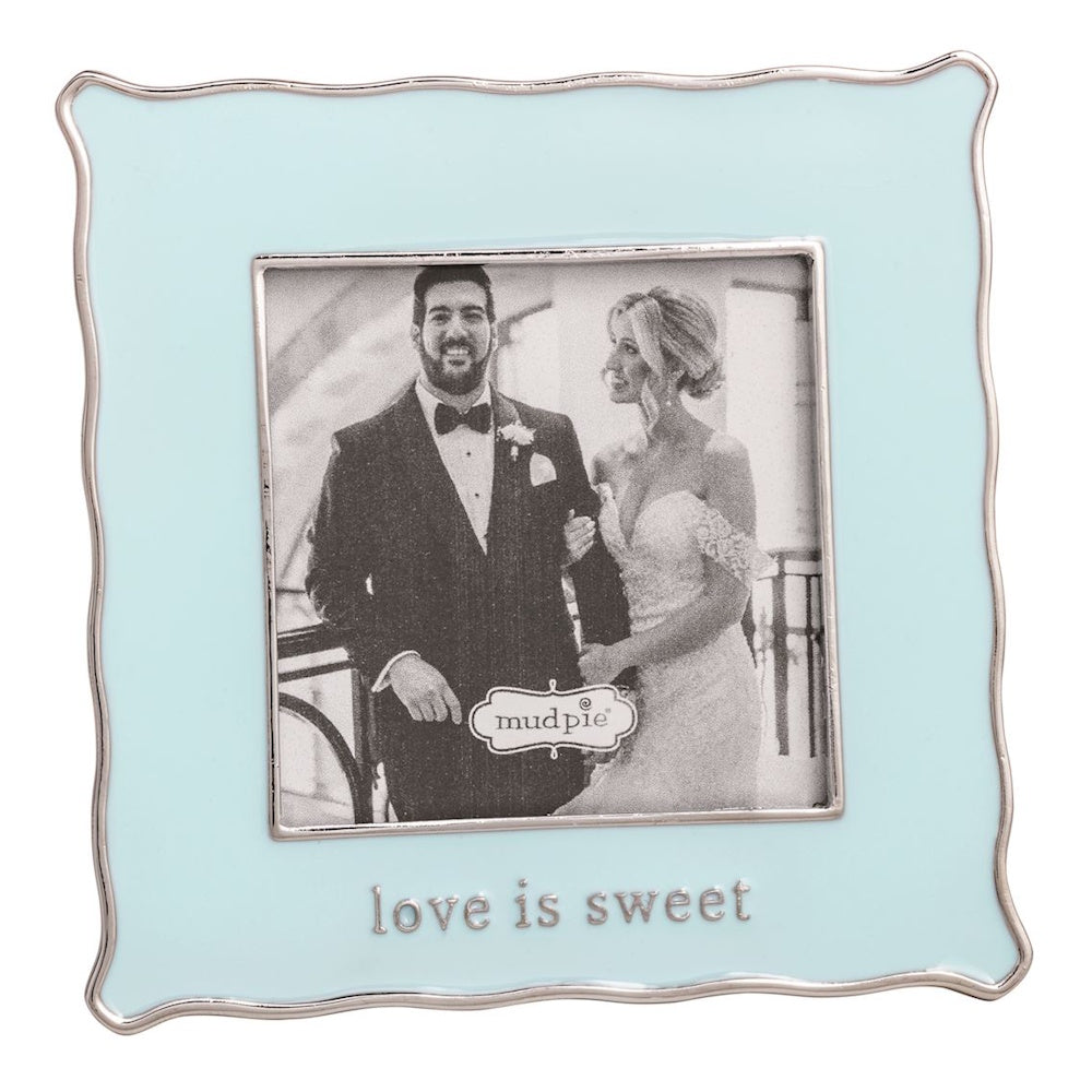 A light blue scalloped square frame containing a wedding photo and the silver-inscribed text "love is sweet."