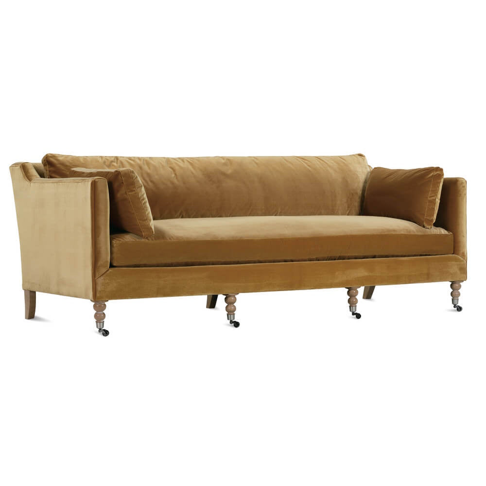 Mid-century modern velvet sofa in mustard gold with turned wooden legs and casters. High armrests and single cushion seat.
