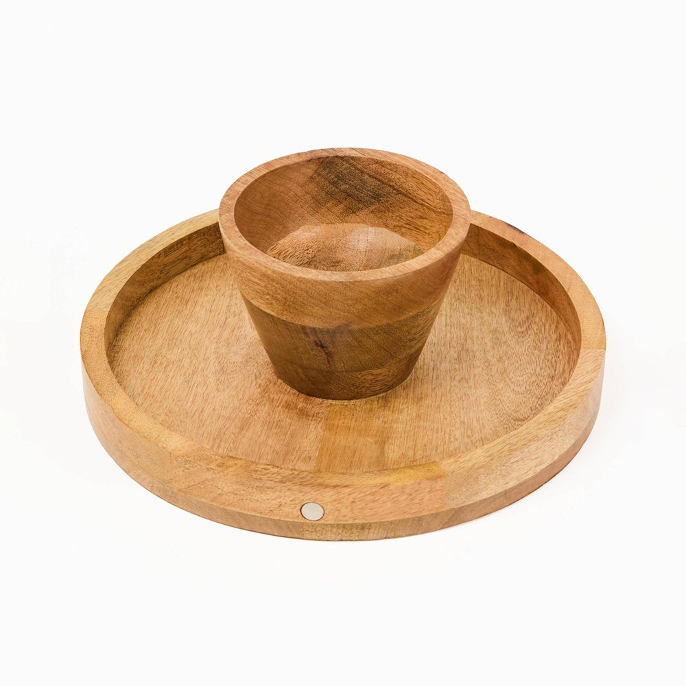 Bottom view of a wooden cake stand base showing a small circular magnet on the rim.
