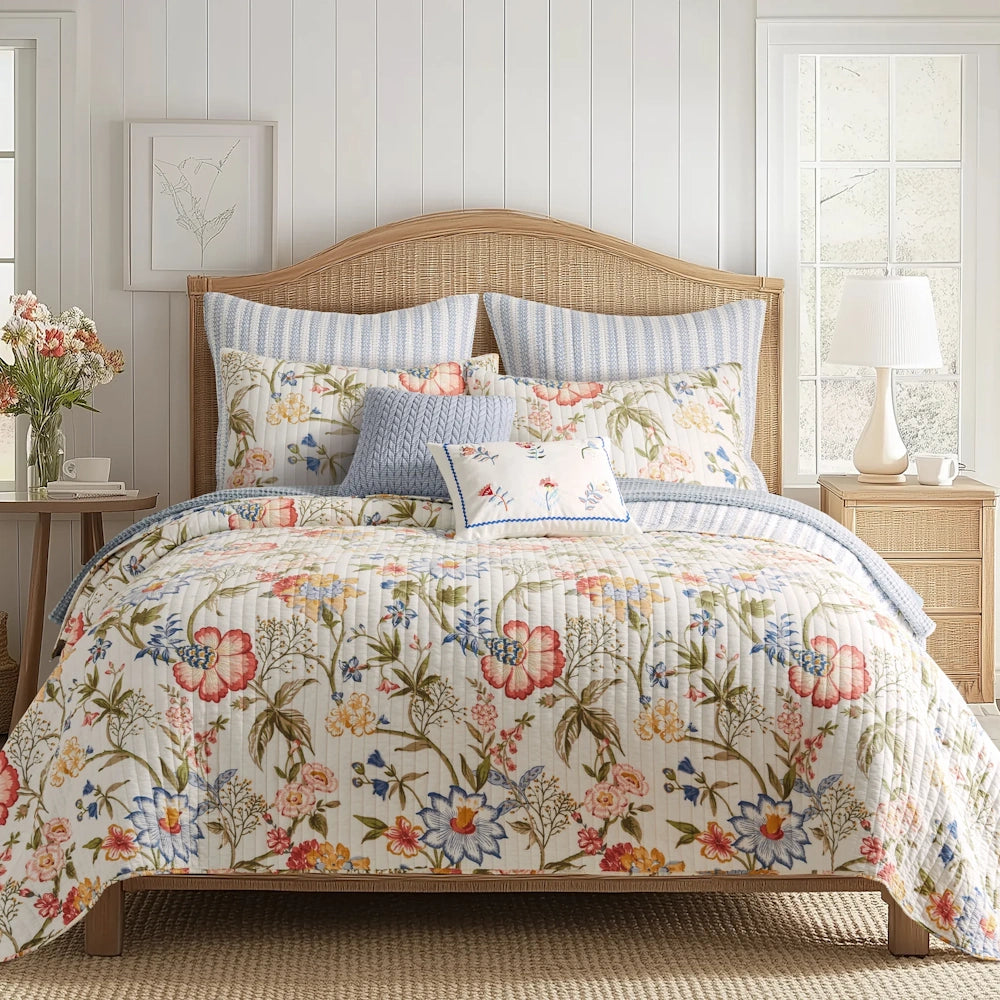 Bed styled with a floral quilt, blue striped shams, blue knit pillow, and a woven wicker headboard.