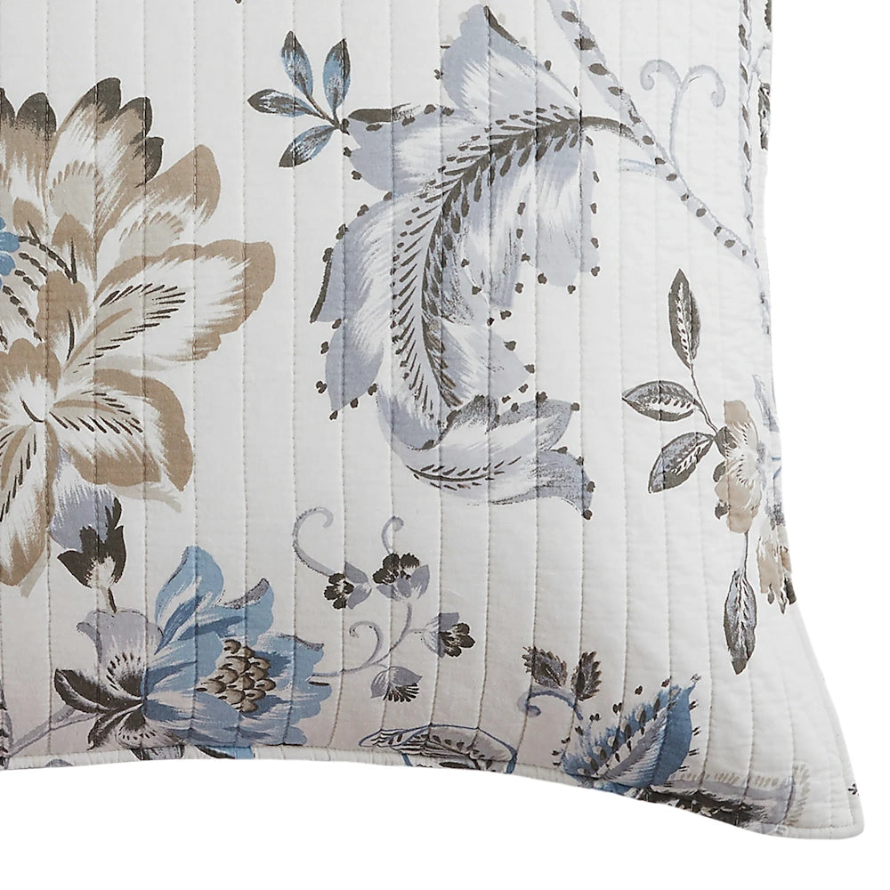Close-up of a quilted pillow sham with a soft blue and beige floral botanical pattern.