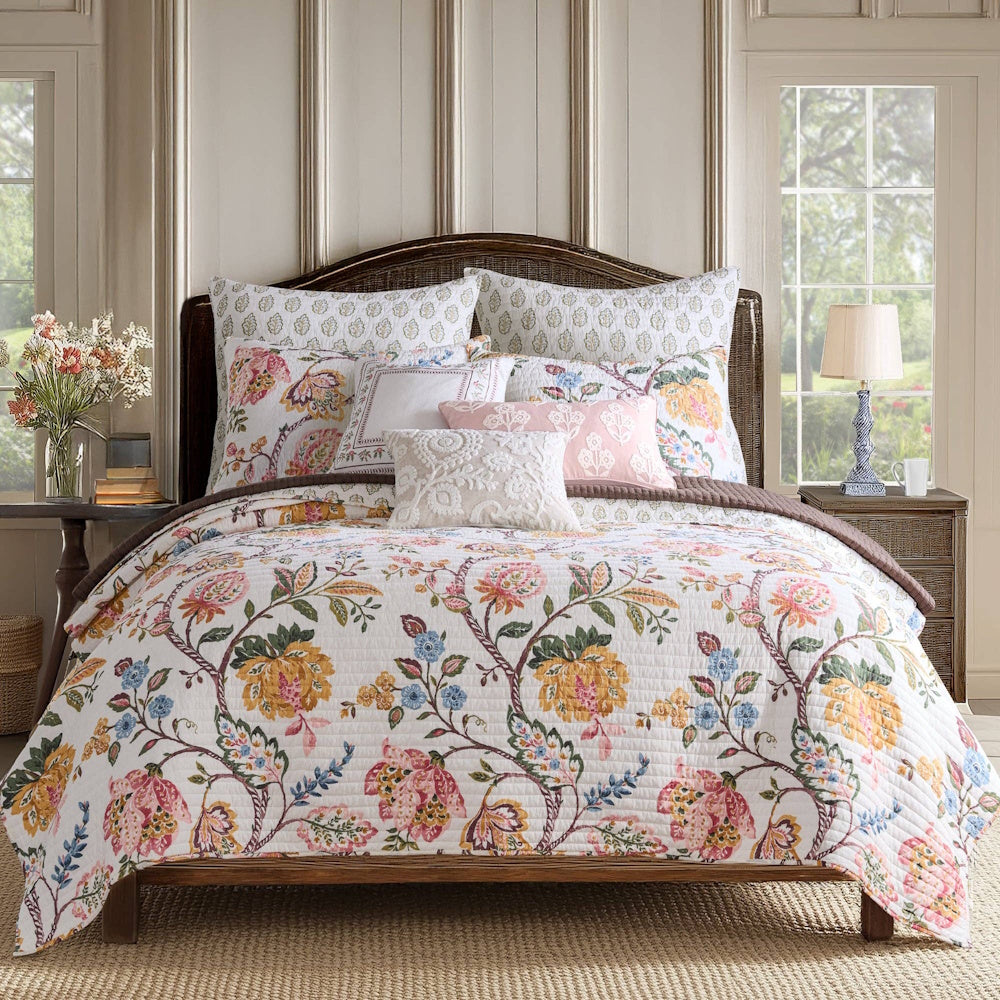 Maileen quilted bedding set with a colorful floral vine pattern on white. Elegant floral quilt and matching pillow shams.