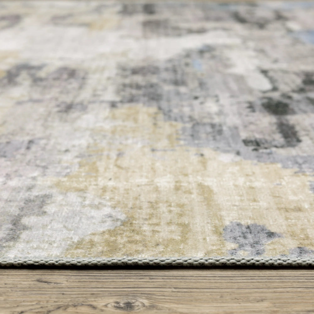 Close-up side view of an abstract, distressed area rug showing its low pile texture on a wood floor.