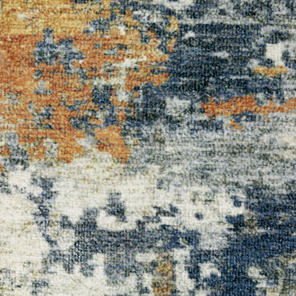 Close-up of a textured rug featuring an abstract, distressed pattern in blue, cream, and orange.