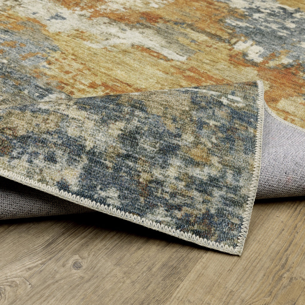 A folded corner of an abstract patterned rug showing the top design, woven edge, and non-slip backing.