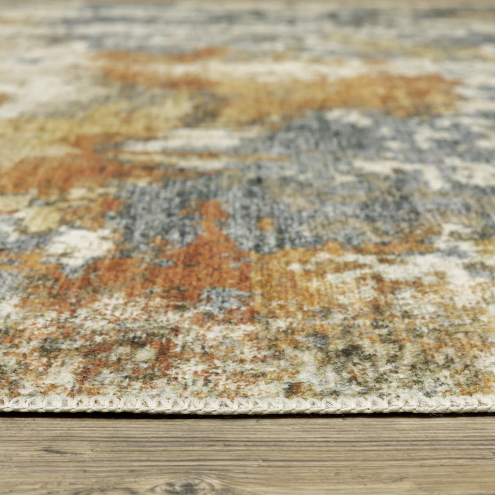 Low-angle view of an abstract-patterned rug on a wooden floor, showing its texture and edge.