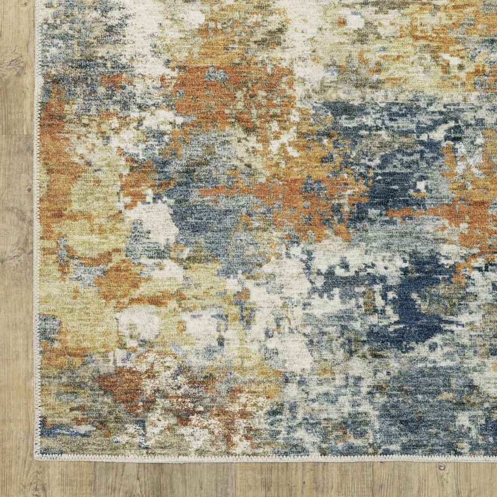 Abstract area rug with a distressed pattern of blue, orange, and cream colors on a wood floor.