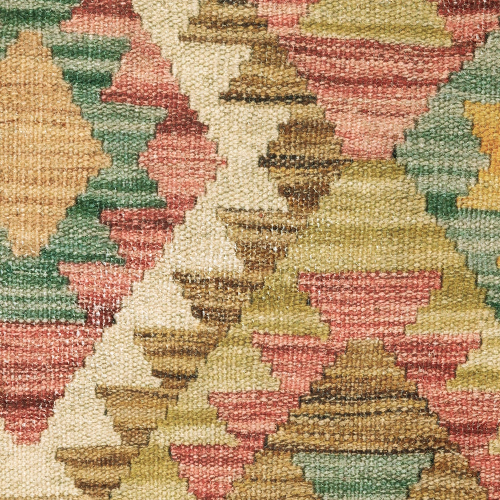 Close-up of a woven flatweave rug showing detailed texture and a colorful geometric diamond pattern.