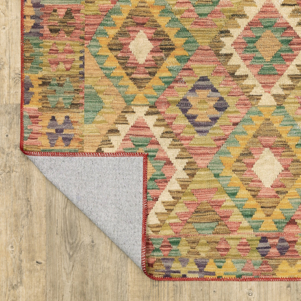 A colorful geometric patterned area rug on a wood floor with one corner flipped over to show the backing.