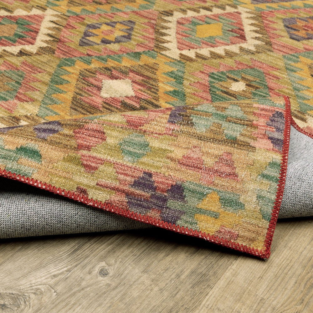 An angled view of a colorful geometric rug with a folded edge, showing both the front pattern and back lining.