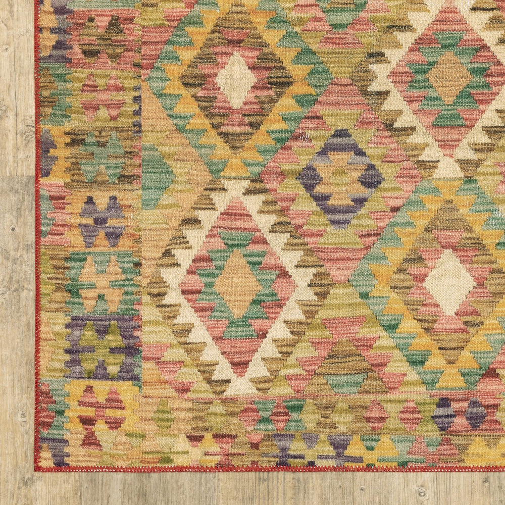 A corner view of a colorful flat-weave kilim rug with geometric diamond patterns on light wood flooring.