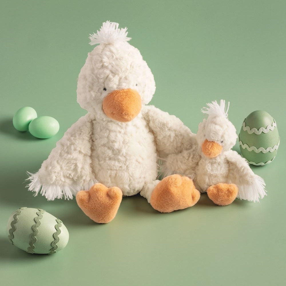 Two plush white duck toys, one large and one small, with orange beaks and feet on a light green background.