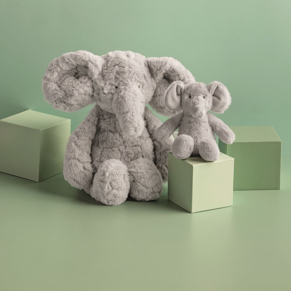 Mama and baby elephant plush toy set on green blocks. Soft grey stuffed animal nursery decor for kids.