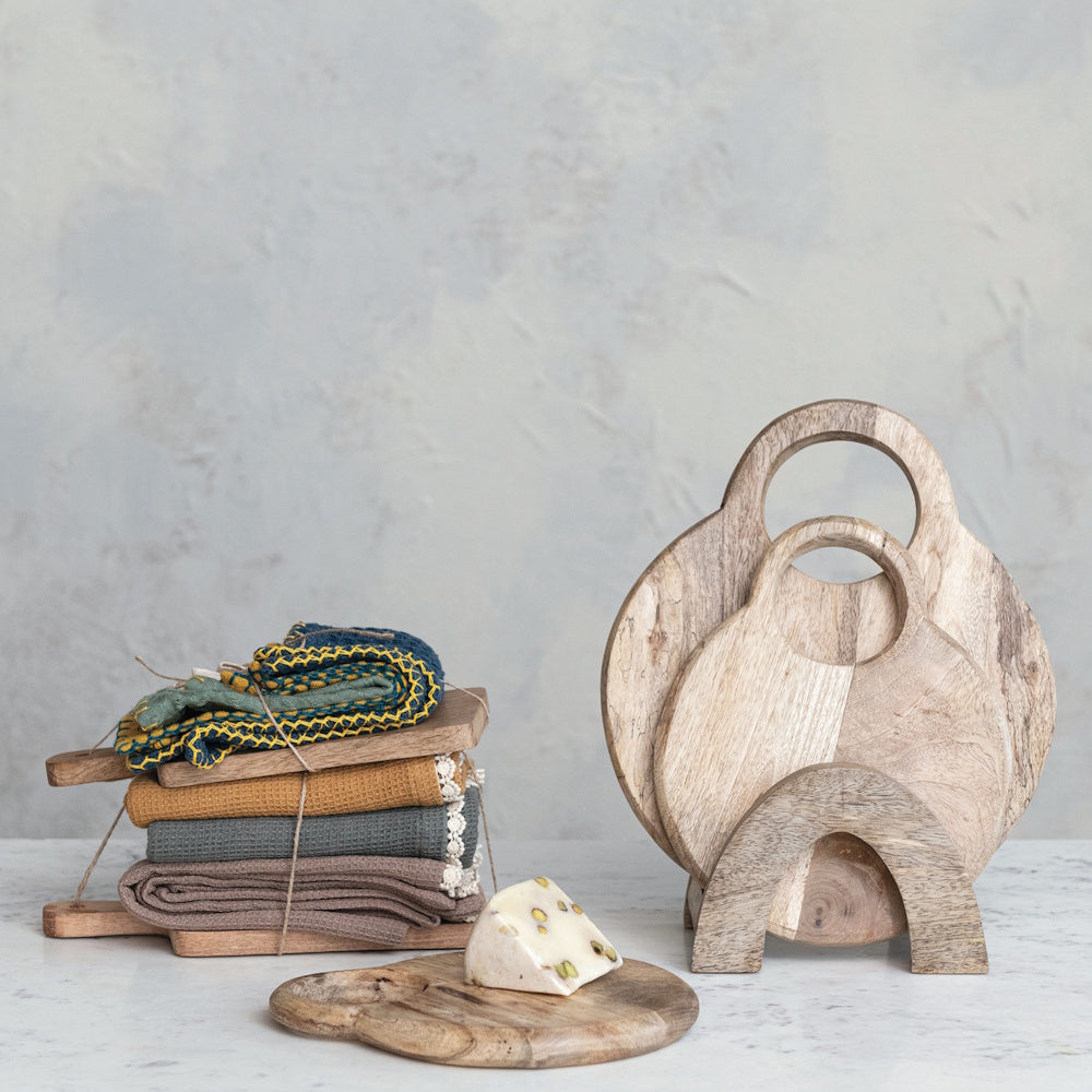 Set of mango wood cheese cutting boards with round handles and a matching storage stand.