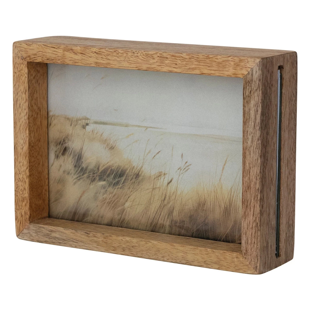 Two-sided mango wood floating photo frame with glass panes and a coastal landscape print on a white background.