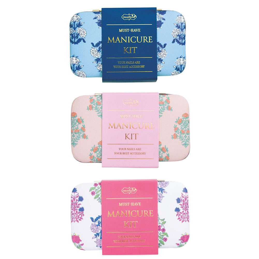 Three floral Mud Pie manicure kits in blue, light pink, and white with pink flowers, featuring gold "Manicure Kit" text.
