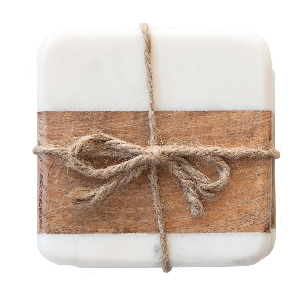 Top view of a stack of square white marble and wood coasters tied together with a twine bow.