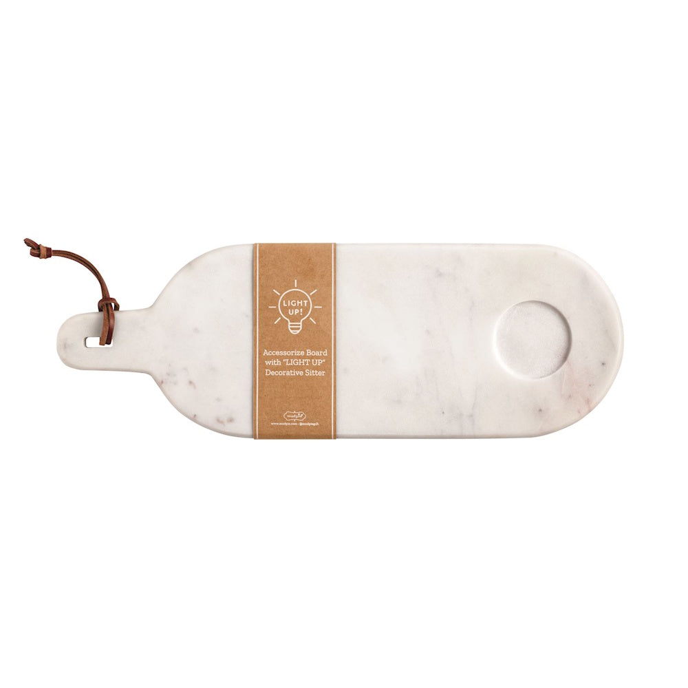 White marble serving board with handle, leather loop, and circular indentation for light-up decorative sitters.