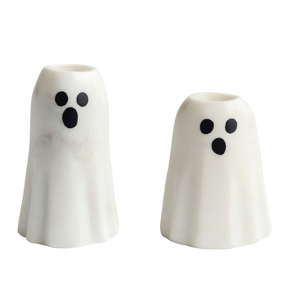 Two white marble ghost-shaped taper candle holders set against a plain background.