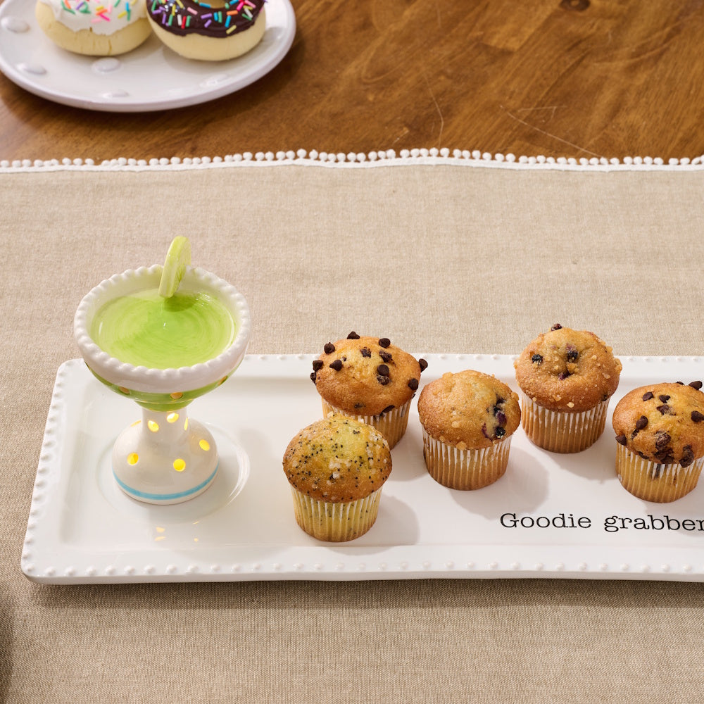 Margarita-shaped light-up sitter on a white "Goodie grabber" tray with assorted mini muffins and donuts on a table.