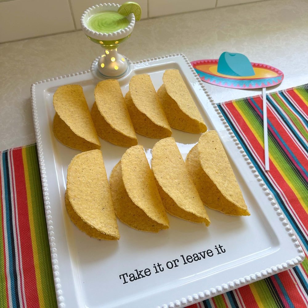 Hard taco shells on a "Take it or leave it" platter with a light-up margarita sitter and a paper sombrero photo prop.