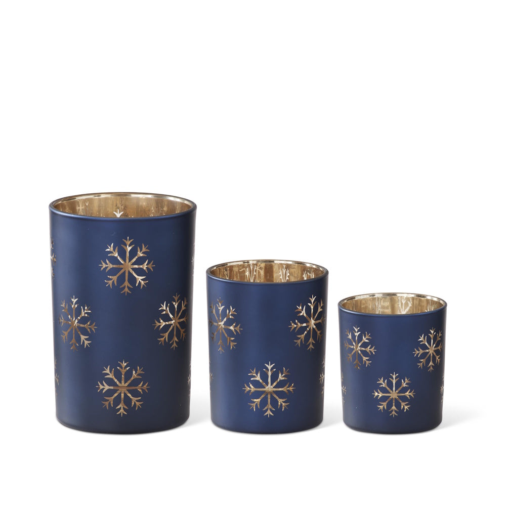 Set of three matte blue glass containers featuring gold snowflake patterns and reflective gold interiors.