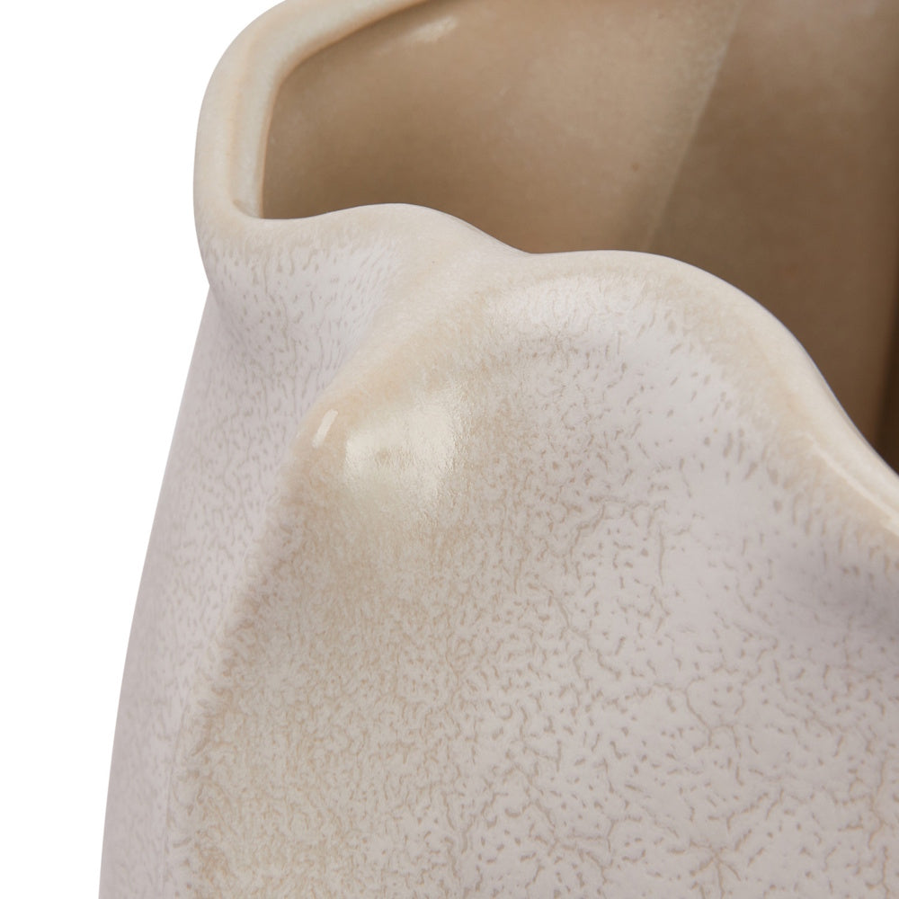 Close-up of the wavy rim of a cream-colored ceramic vase with a subtle, textured crackle glaze.