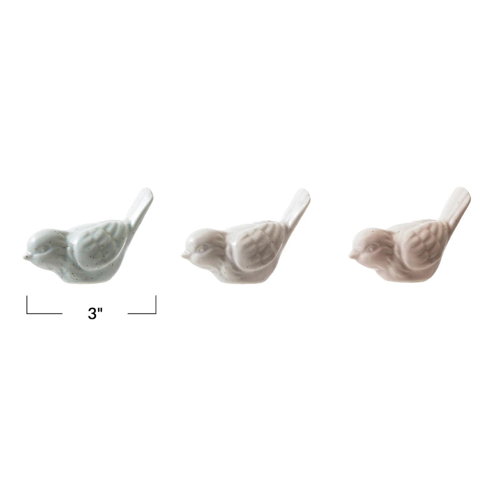 Three 3-inch matte stoneware bird figurines in muted blue, grey, and pink tones on a white background.